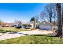 Charming home with light green siding, large front lawn, and mature trees on a sunny day at 3863 Shakespeare Dr, Hickory, NC 28601