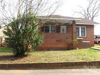 Charming brick home featuring a cozy front porch and mature landscaping at 39 Railroad St, Lincolnton, NC 28092