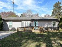 Ranch style home with a teal door, wheelchair ramp, and a well-maintained lawn at 464 Willetta Nw Pl, Concord, NC 28027