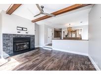 Inviting living room featuring wood floors, fireplace, ceiling fan, and beautiful wood beam accents at 5194 Corbin Ln, Hickory, NC 28601