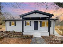 Charming home with black and white accents, a cozy front porch, and inviting curb appeal at 5674 Alan D Good Ln, Conover, NC 28613