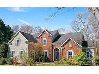 Charming two-story brick home with a manicured lawn and mature trees in a quiet neighborhood at 10122 Deer Brook Ln, Charlotte, NC 28210