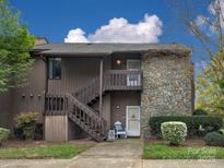 Two-story condo with a stone facade and wood siding, complimented by mature trees and landscaping at 1022 Mallard Head Ln, Mooresville, NC 28117