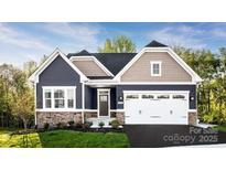 Charming two-story home featuring a two-car garage, stone accents, and manicured lawn at 1208 Cottage Green Dr # 0140, Monroe, NC 28112