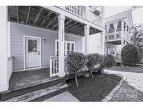 Charming home featuring a classic front door, covered porch, and beautifully manicured landscaping at 12304 Huntersville Concord Rd, Huntersville, NC 28078
