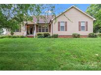 Charming single-story home featuring a well-manicured lawn and a welcoming front porch with brown shutters at 1278 Gracebrook Dr, Salisbury, NC 28147