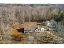An aerial view of a home surrounded by woods showcasing the property and its surroundings at 1298 Hines Rd, Clover, SC 29710