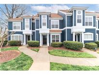 Charming blue townhome featuring well-maintained landscaping, inviting entrance, and a pathway to the front door at 17537 Tuscany Ln, Cornelius, NC 28031