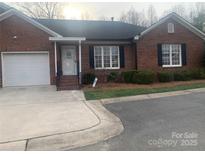 Charming brick home featuring a one-car garage and a cozy front porch entrance, providing a welcoming curb appeal at 2207 Windsor Woods Dr, Gastonia, NC 28054