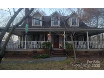 Inviting two-story home featuring a charming, covered front porch and dormer windows at 2718 Tara Dr, Monroe, NC 28112
