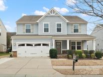 Charming two-story home featuring a well-manicured lawn, attached two car garage, and inviting front porch at 3015 Fallondale Rd, Waxhaw, NC 28173