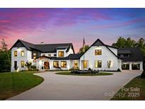 Stunning modern farmhouse with circular drive, manicured lawn, and elegant black and white design at 406 Morrison Farm Rd, Troutman, NC 28166
