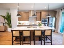 Bright kitchen featuring a quartz island with seating and modern stainless-steel appliances at 408 Old Town Village Rd, Waxhaw, NC 28173