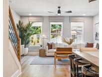 Bright living room with large windows, modern decor, and hardwood floors at 408 Old Town Village Rd, Waxhaw, NC 28173