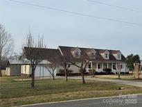 Inviting one-story home boasting a covered front porch, attached garage and large, grassy front lawn at 6795 Jones Rd, Salisbury, NC 28147