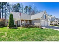 Charming home featuring a well-manicured lawn, stone accents, and a two-car garage at 7331 Sedgebrook W Dr, Stanley, NC 28164