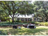 Inviting front yard featuring mature trees and an outdoor seating area with beautiful landscaping at 7794 Live Oaks Dr, Denver, NC 28037