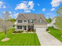 Beautiful two-story home with manicured lawn, stone accents, and an attached two-car garage at 963 Brookdale Ln, Stanley, NC 28164