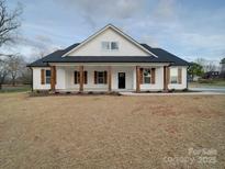Beautiful white single-story home boasts charming wooden shutters and a welcoming front porch with stylish columns at 0000 Trull Hinson Rd # 2, Wingate, NC 28174