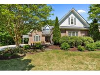 Charming brick home featuring lush landscaping, mature trees, and a welcoming entrance at 1040 Lyndon Dr, Lancaster, SC 29720
