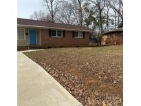 Charming brick home with a well-maintained lawn and a bright blue front door at 1111 Pondella Dr # 66, Charlotte, NC 28213