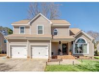 Charming two-story home featuring a three-car garage, large windows, and well-maintained landscaping at 112 Northhampton Dr, Mooresville, NC 28117
