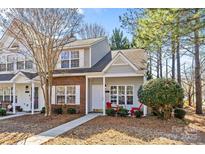 Charming townhome featuring a brick facade, covered porch, and well-maintained landscaping at 12871 Mosby Ln, Charlotte, NC 28273