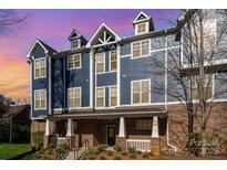 Striking blue townhouse exterior with brick facade and inviting covered entry at 1525 Walnut View Dr, Charlotte, NC 28208