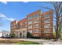 Side view of brick building with manicured lawn and mature trees, exhibiting timeless charm and architectural details at 2445 Selwyn Ave, Charlotte, NC 28209