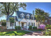 Charming two-story white brick home with black shutters, dormers, and mature landscaping at 3133 Selwyn Ave, Charlotte, NC 28209