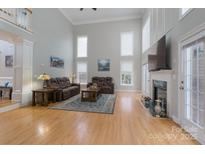 Bright and open living room with hardwood floors, fireplace, and abundant natural light from the windows at 3304 Taviston Dr, Waxhaw, NC 28173