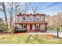 Charming two-story home with a covered front porch and well-manicured landscaping at 335 Deep Forest Ct, Gastonia, NC 28056