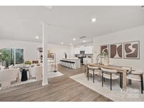 Open concept living room and kitchen with modern white cabinets, a dining area and hardwood floors at 336 Ginsberg Rd, Rock Hill, SC 29732