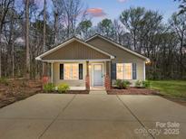 Charming single-story home with neutral siding, brick accents, a well-manicured lawn, and a spacious concrete driveway at 350 Belvedere Nw Dr, Concord, NC 28027