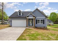 Charming home featuring a two-car garage, dormer window, and gray siding at 409 Bost St, Kannapolis, NC 28081