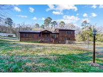 Charming two-story home with rustic wood siding and a well-maintained front yard at 455 Pinhook Loop Rd, Gastonia, NC 28056