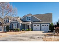 Charming home featuring gray siding, a well-manicured lawn, and a three-car garage at 5009 Henshaw Rd, Waxhaw, NC 28173