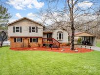 Charming two-story home with a well-maintained lawn, colorful mulch, and mature trees in a residential neighborhood at 5412 Carving Tree Dr, Harrisburg, NC 28075