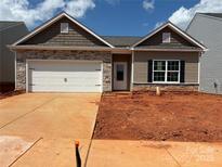 Charming single-story home featuring a stone facade, attached garage, and a well-manicured lawn at 5708 Skinny Dr, Charlotte, NC 28215