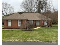 Charming brick home featuring manicured lawn and mature landscaping adding curb appeal at 861 Emerson Dr, Mooresville, NC 28115