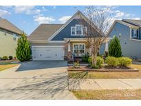 Charming single-Gathering home with a well-maintained lawn, attached garage, and welcoming front porch at 1037 Delridge St, Waxhaw, NC 28173