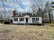 Charming one-story home featuring dormer windows and a red brick chimney at 10516 Hambright Rd, Huntersville, NC 28078