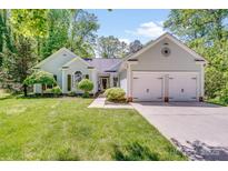 Charming home with a well-manicured lawn, lush landscaping, and a two-car garage at 11003 Pale Hickory Ln, Charlotte, NC 28215