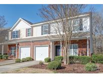 Charming townhome with brick and vinyl siding, two garage doors, and manicured landscaping at 114 Clydesdale Ct, Matthews, NC 28104