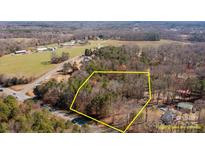 An aerial view of a wooded lot surrounded by mature trees and bordered by a road, ready for a custom-built home at 12538 Sam Furr Rd, Huntersville, NC 28146