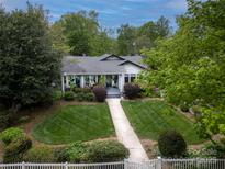Charming home with a well-manicured lawn, mature trees, and a welcoming walkway to the front door at 1519 The Plz, Charlotte, NC 28205