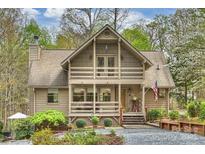 Charming home features a porch with an American flag, beautiful landscaping, and a welcoming entrance at 2819 Blythe Rd, Waxhaw, NC 28173