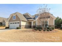 Charming single-story home featuring a two-car garage, stone accents, and manicured landscaping at 3102 Arches Bluff Cir, Lancaster, SC 29720