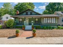 Charming green bungalow-style home featuring a cozy front porch and beautifully landscaped yard at 36 Yorktown Nw St, Concord, NC 28025