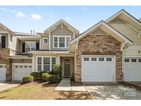 Charming townhome with stone accents, a one-car garage, and a well-manicured front yard at 5959 Pale Moss Ln, Charlotte, NC 28269